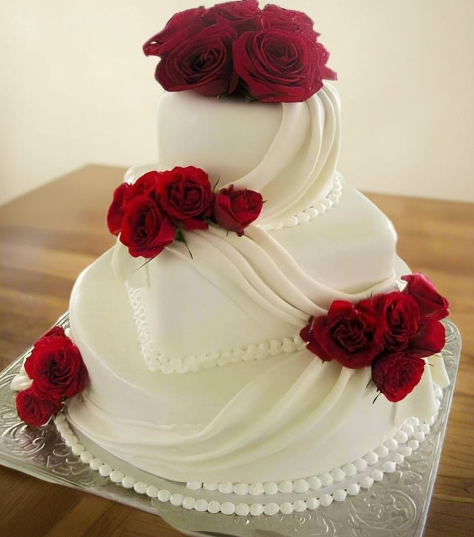 Wedding Special Cake — flowing white bands and red rose decoration; India