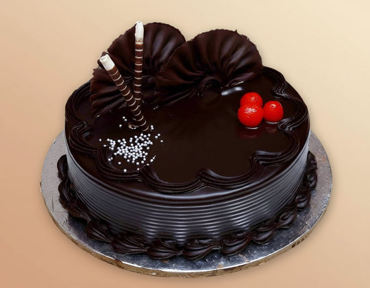 Chocolate Flower Cake — dark glaze, red cherries and fan-shaped topping pieces; India