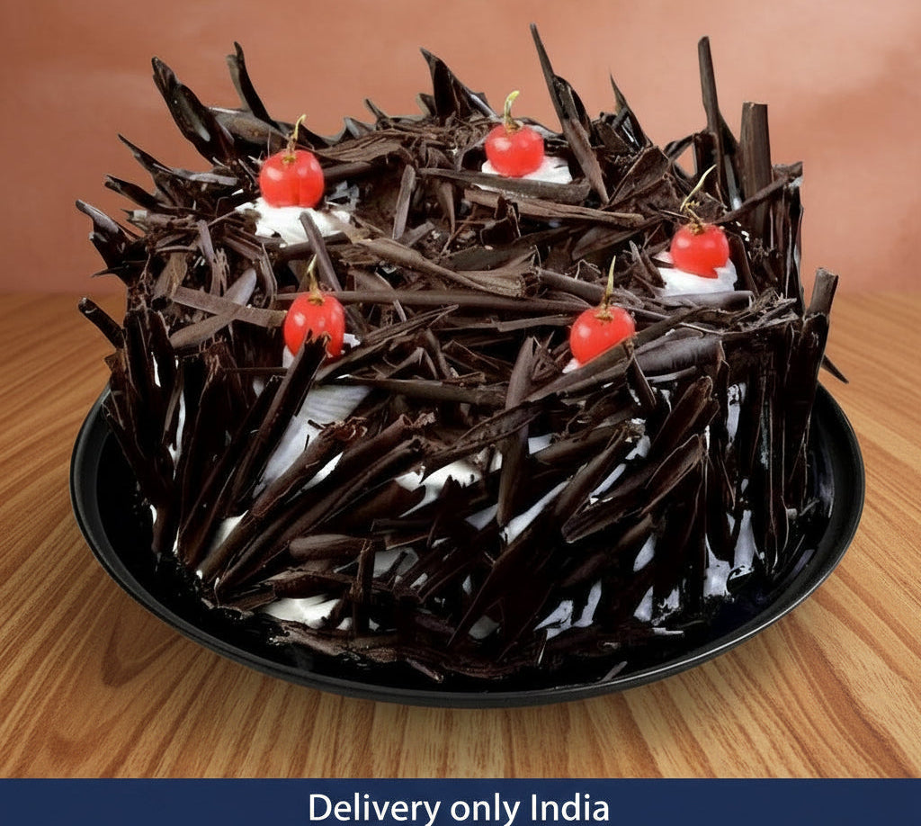 Round Black Forest cake covered in dark chocolate shavings with red cherries and white cream – India