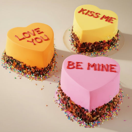 3 Heart Shaped Combo Cake — three brightly coloured heart cakes with love-themed messages; India