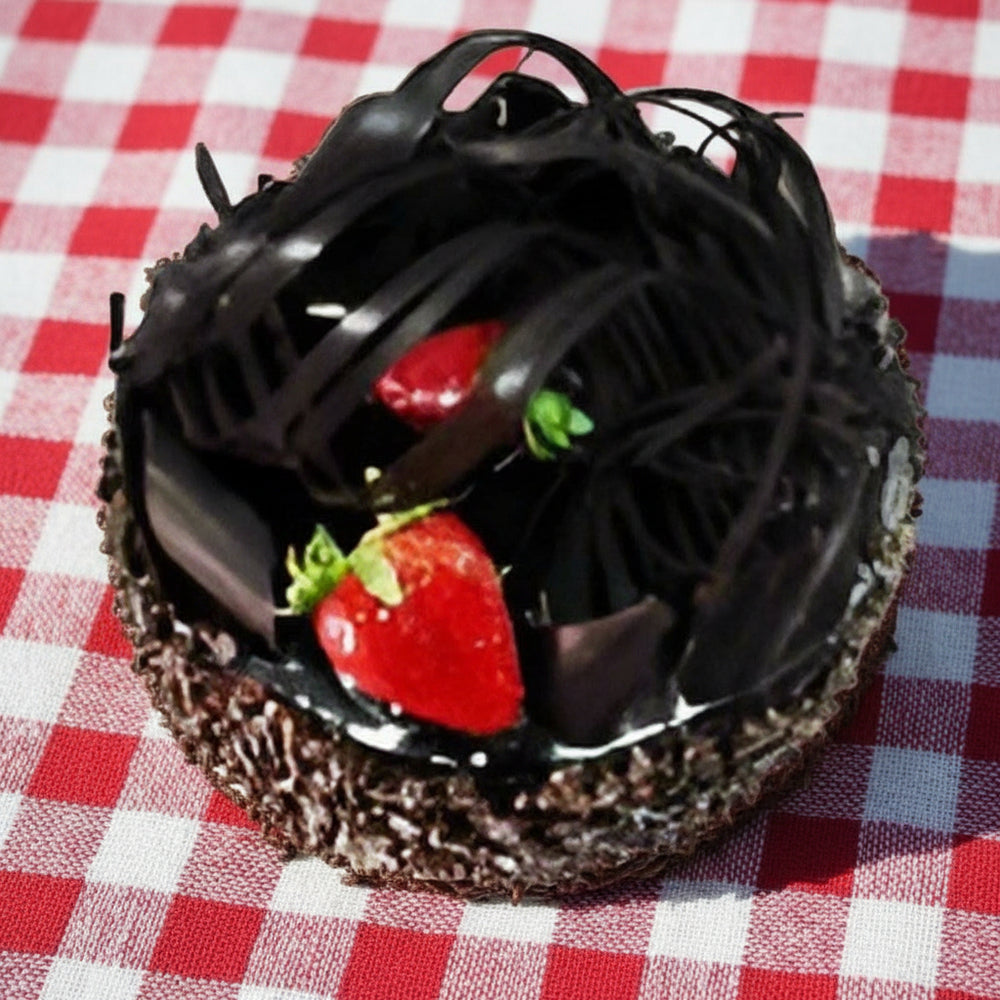 Chocolate Crisp Cake — dark curved topping pieces and strawberry accents; India