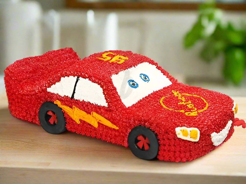 Car Theme Cake — a red racing-car body with yellow lightning details; India