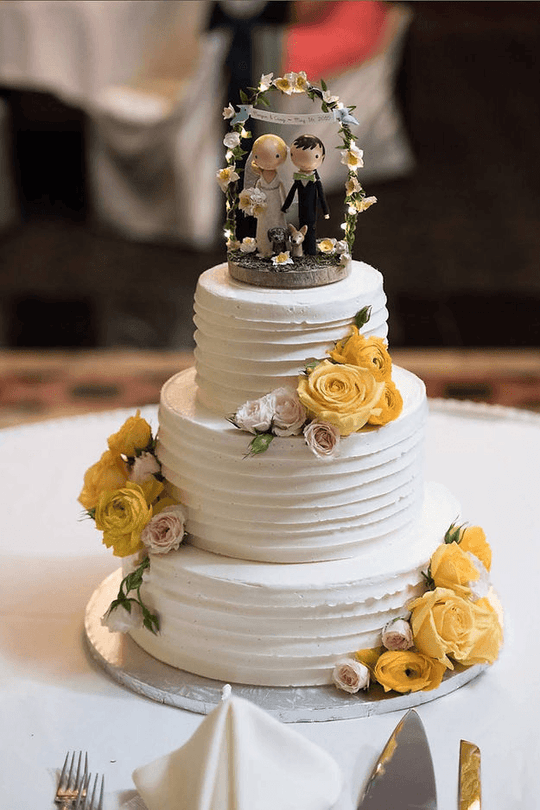 Gold Rose Elegant Wedding Cake — white wedding tiers with gold roses and couple topper; India