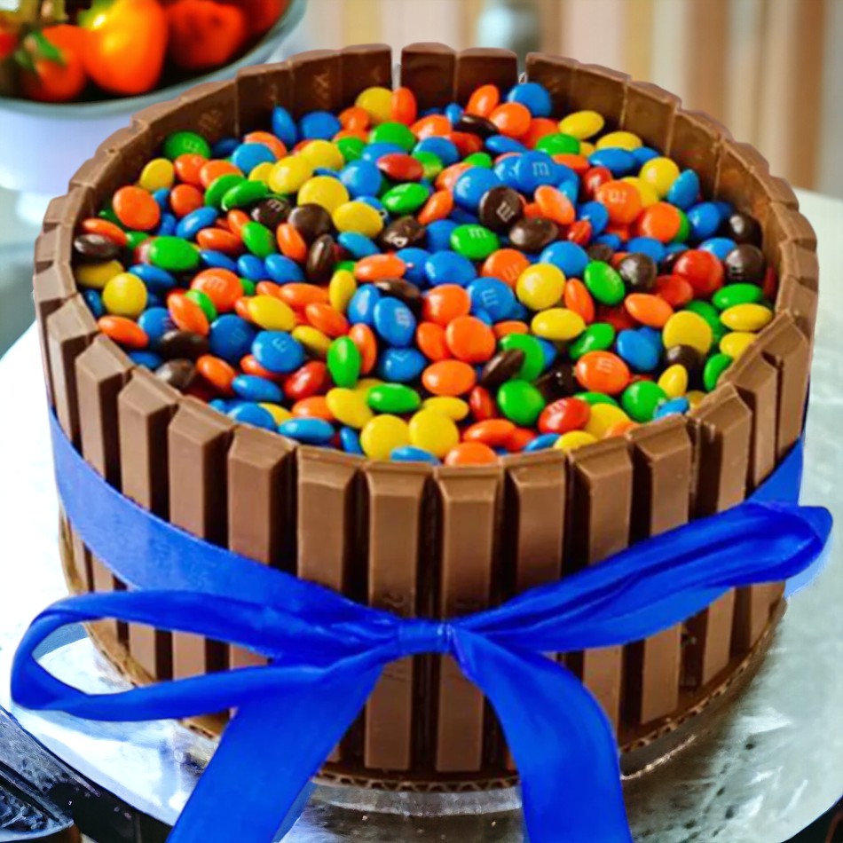 KitKat Candy Cake with Blue Ribbon — chocolate-bar sides, colourful candy topping and a blue ribbon; India