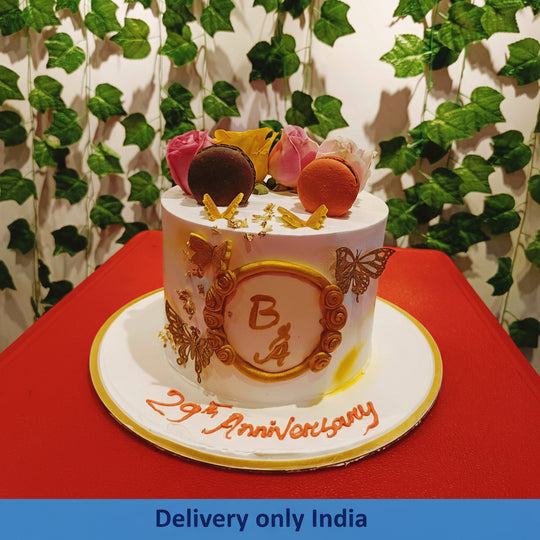 Fruit Topped Anniversary Cake — golden printed-style anniversary decoration and fruit topping; India