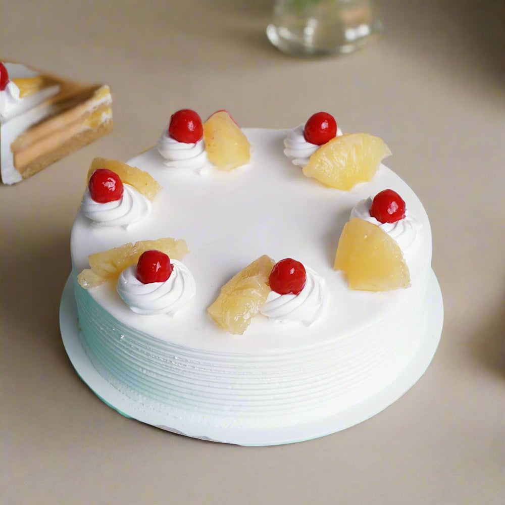 Fruit Topped Pineapple Cake — white cream dollops, pale fruit pieces and red cherries; India