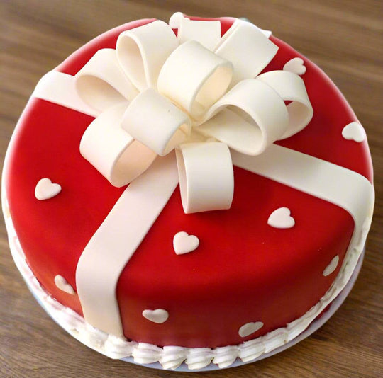 Cake Gift — red gift-wrap design, white ribbon and a large bow; India