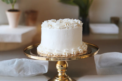 Elegant vanilla cake on a gold stand, perfect for UAE delivery