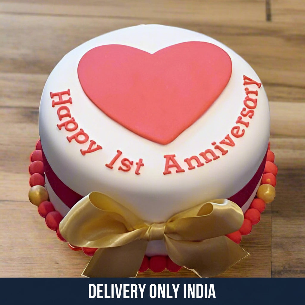 1st Anniversary Cake — white finish with a large pink heart and gold bow; India