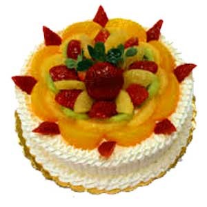 Fruit Celebration Cake — white piped tiers topped with a mixed-fruit cluster; India
