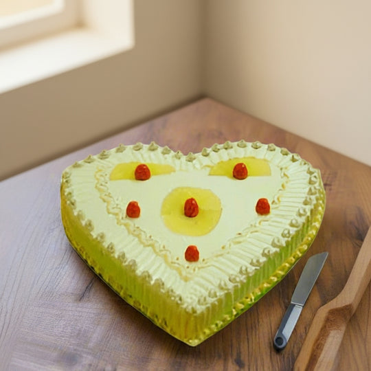 Heart-Shaped Pineapple Cake — yellow cream piping and fruit-like red accents; India