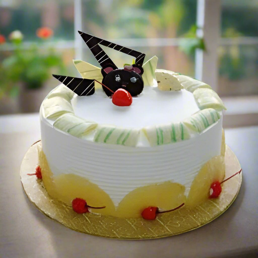 Pineapple Round Cakes — white cream, yellow accent band and geometric dark decorations; India
