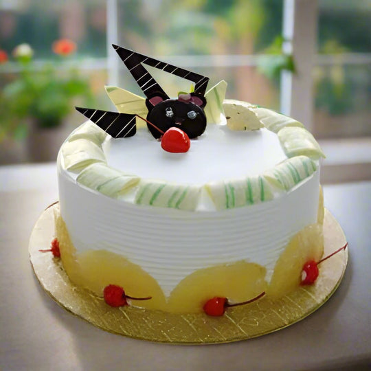 Pineapple Round Cakes — white cream, yellow accent band and geometric dark decorations; India