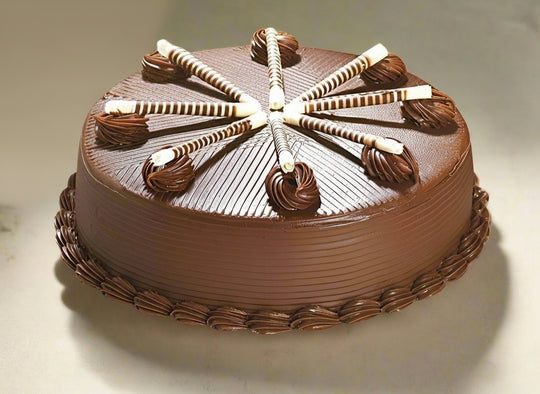 Yummy Chocolate Cake — brown piped sides and striped decorative sticks; India