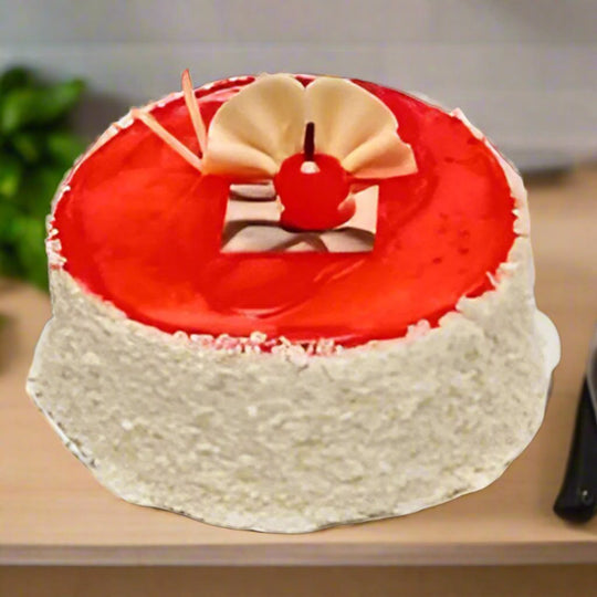 Pineapple Yummy Cake — red glazed top, white textured sides and pale curled pieces; India