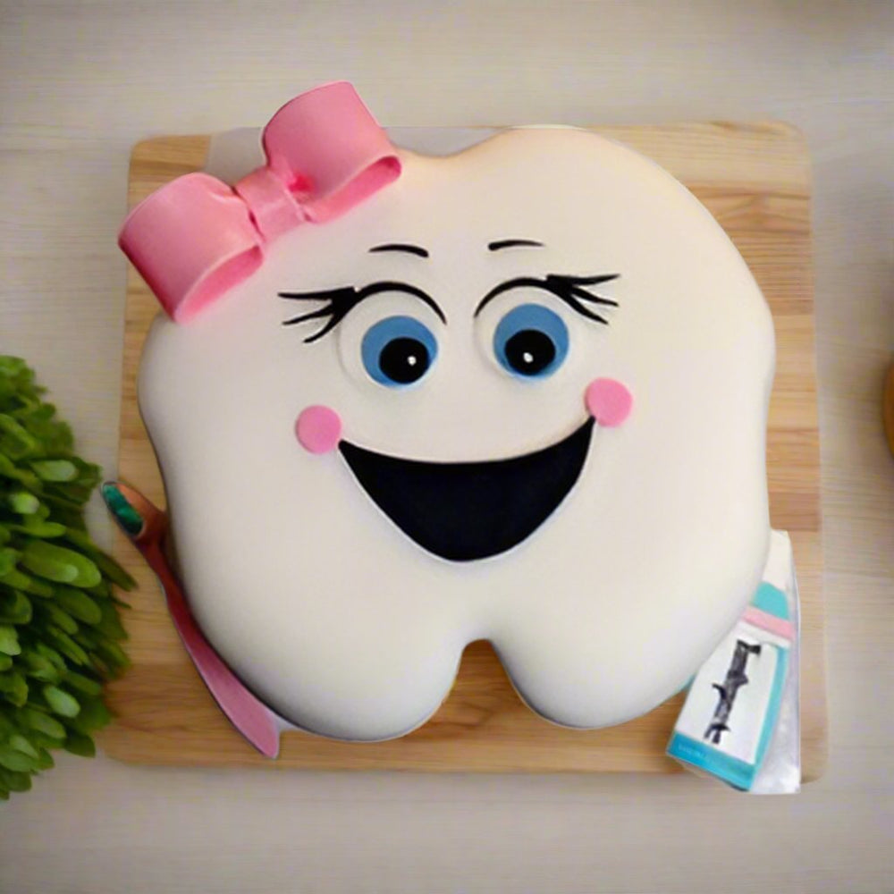 Happy Tooth Cake — a smiling tooth character with pink bow; India