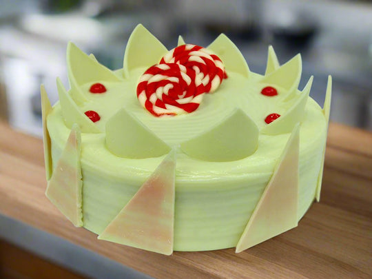 Litchi Delight Cake — pale green finish, pointed decorative panels and a central cream swirl; India