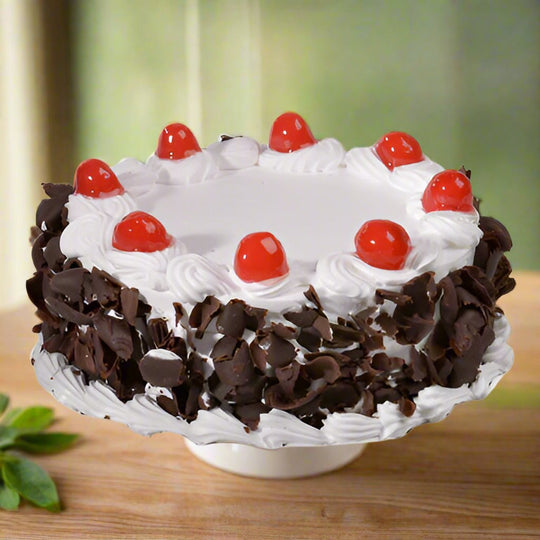 Simple Black Forest Cake — white cream rosettes, chocolate shavings and cherries; India