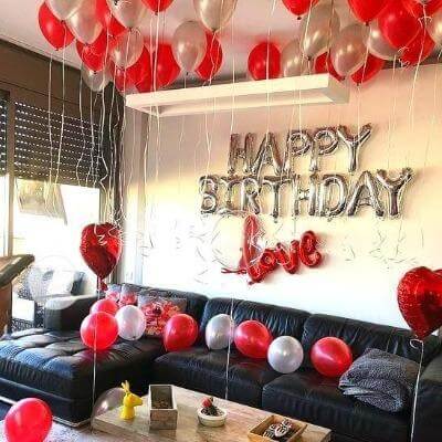 Romantic happy birthday love decor with balloons and cake setup
