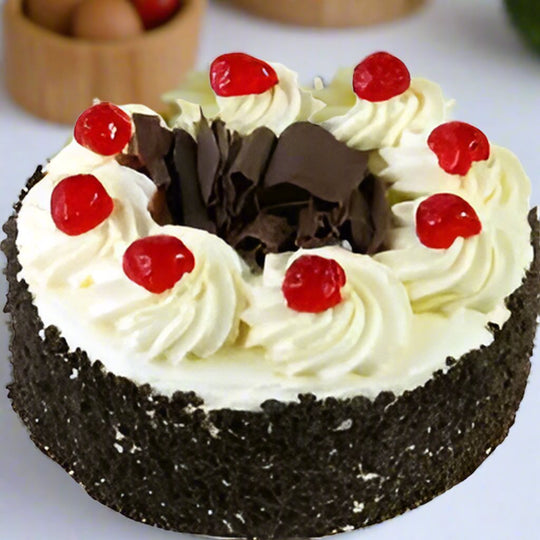 Yummy Black Forest Cake — dark crumb-covered sides, white cream and red cherries; India