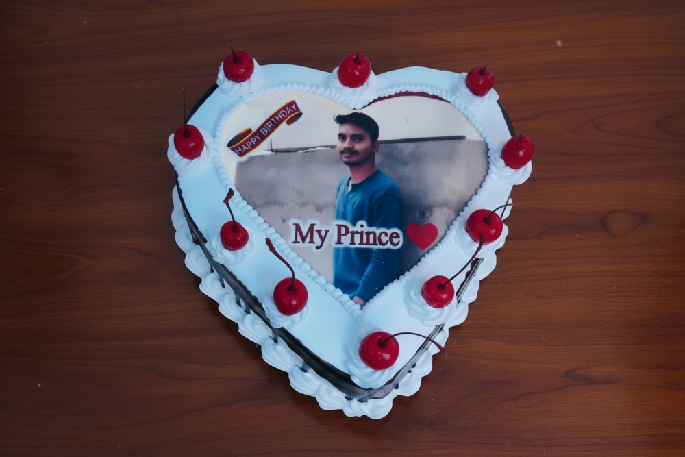Celebration Heart-Shaped Photo Cake — a printed photo centre with red cherry accents; India
