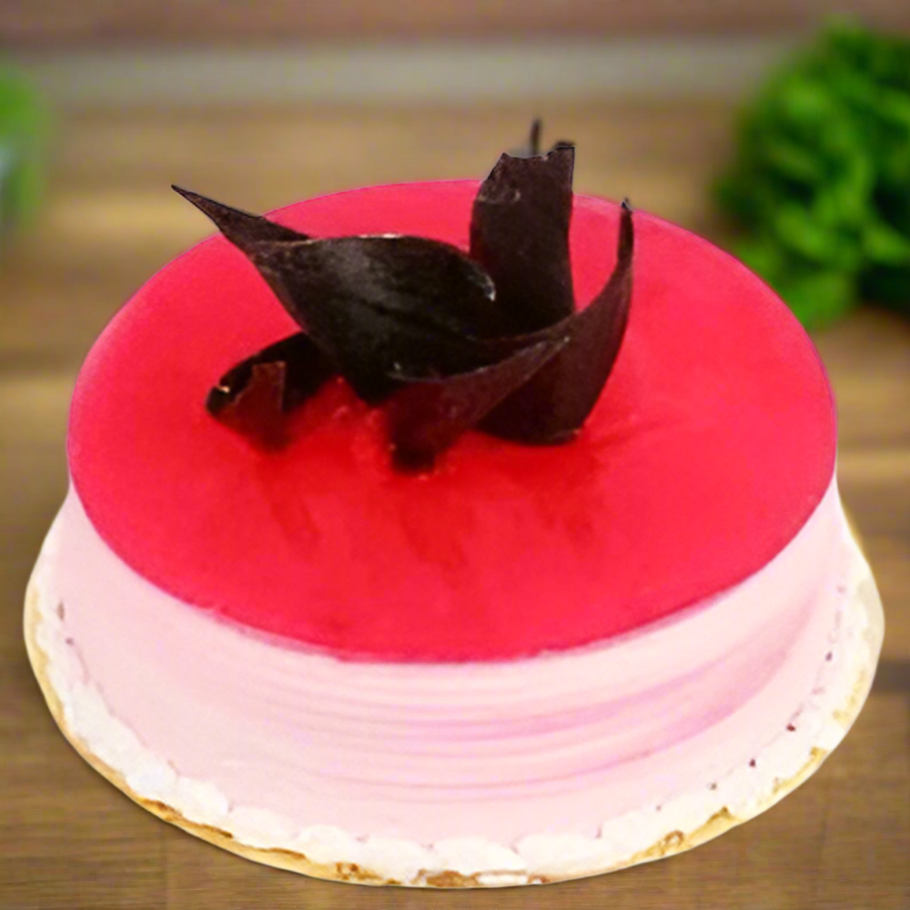 Pineapple Delight Cake — pink glazed top and dark curled topping pieces; India