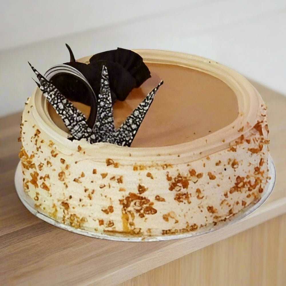 Butterscotch Delight Cake – Half kg – India — pale crumb-speckled finish and a contrasting decorative cluster; India
